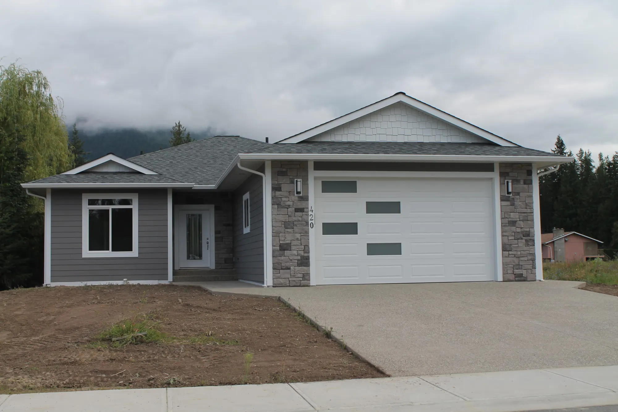 Modern garage door with staggered glass panels installed in Sicamous